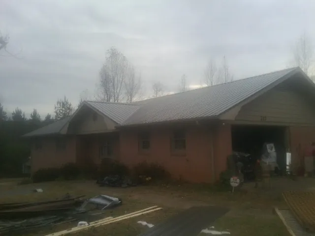 Gray metal roof on a stucco house with an attached garage in Harrisburg